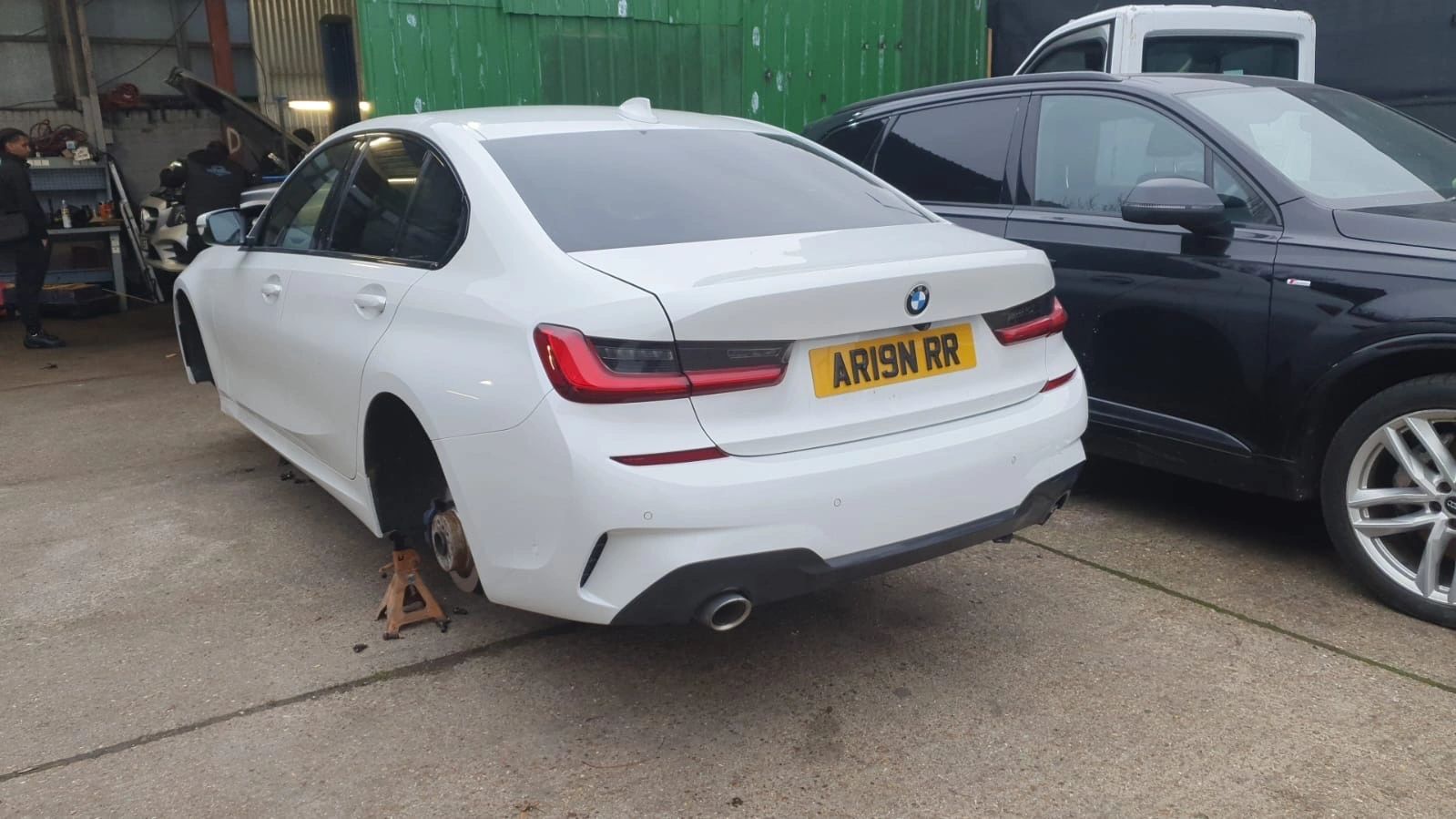 White BMW on stands with the wheels off and brakes exposed